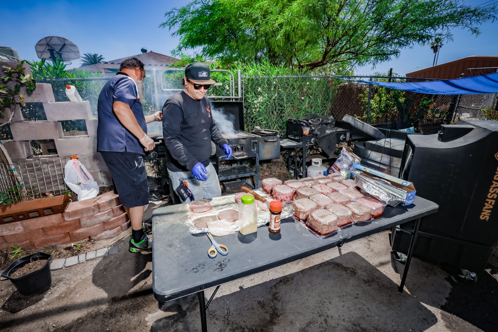 Two men grilling burgers for community event