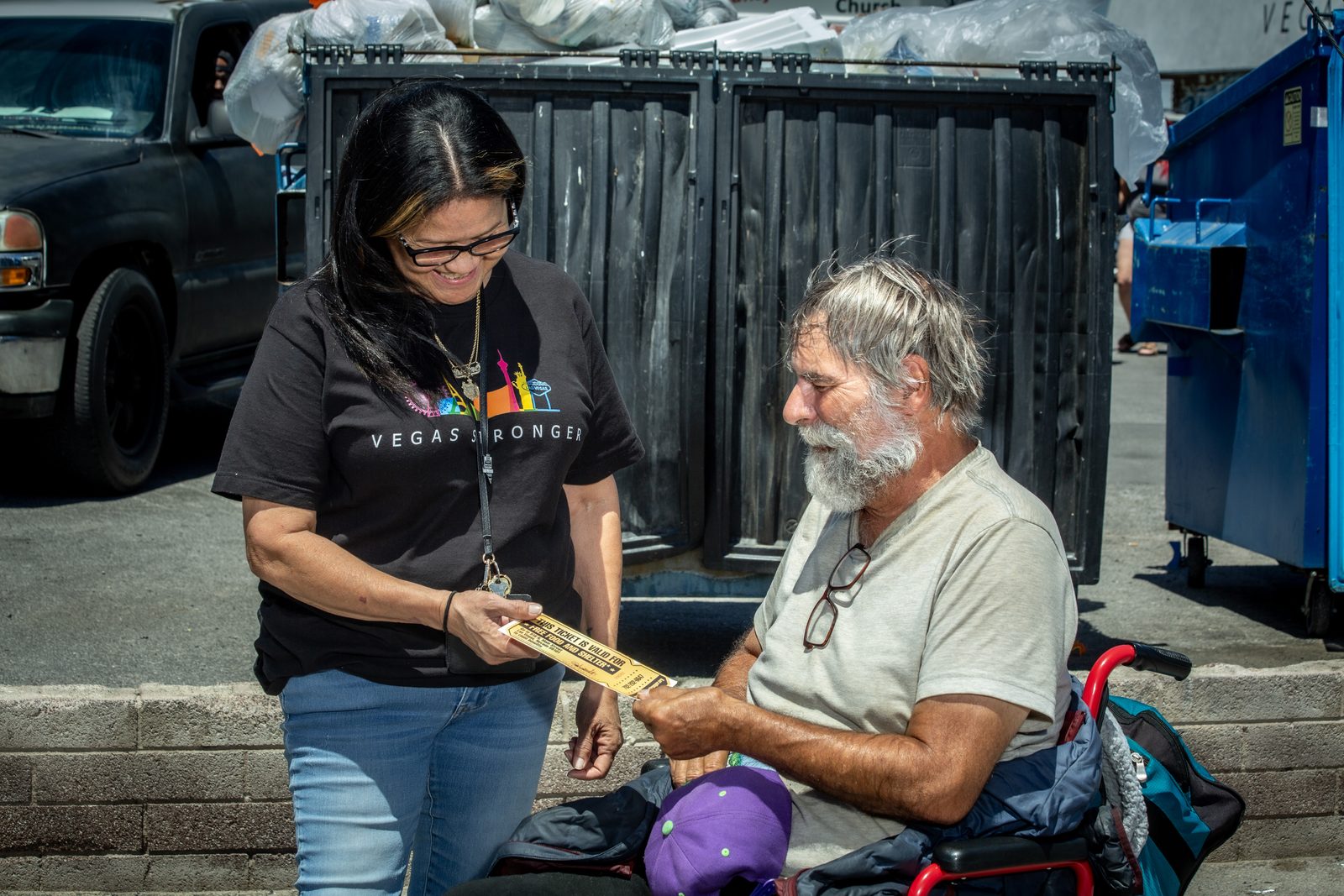 Staff member smiling while assisting homeless man