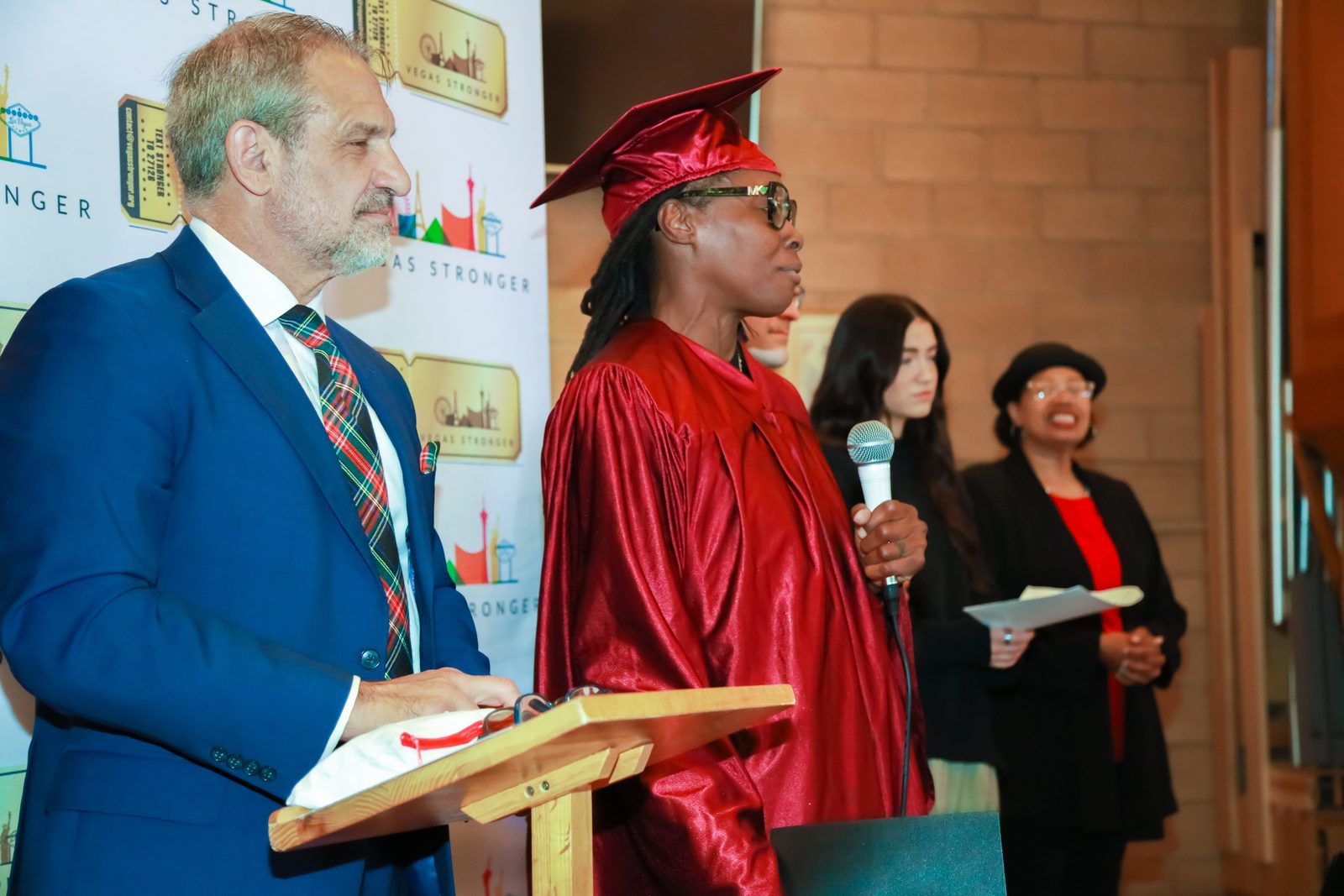 Graduate speaks beside presenter at Vegas Stronger ceremony