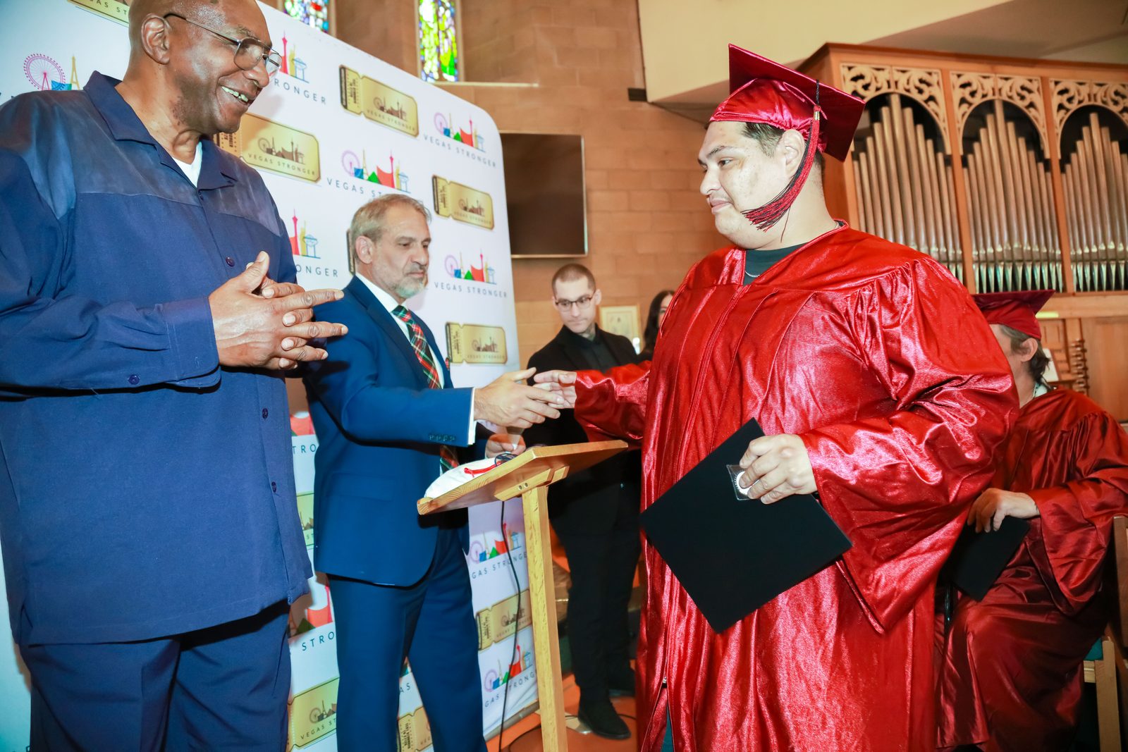 Graduate receives diploma congratulations at Vegas Stronger event