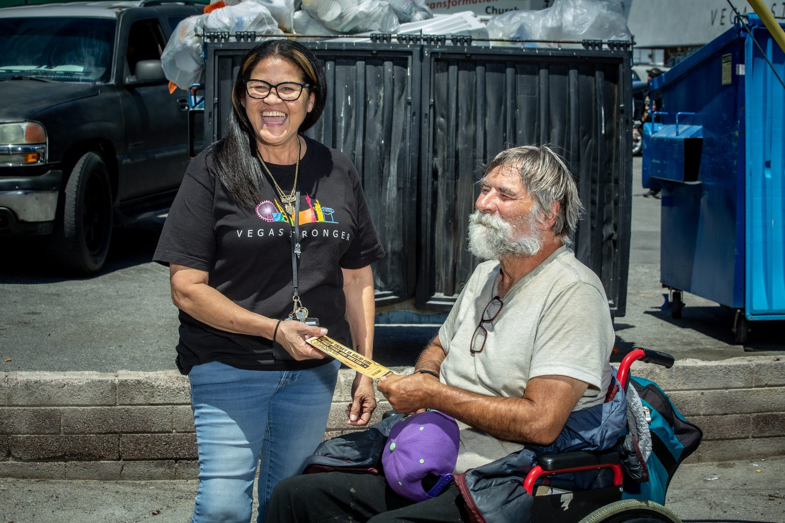 Smiling staff member helps homeless man in Las Vegas