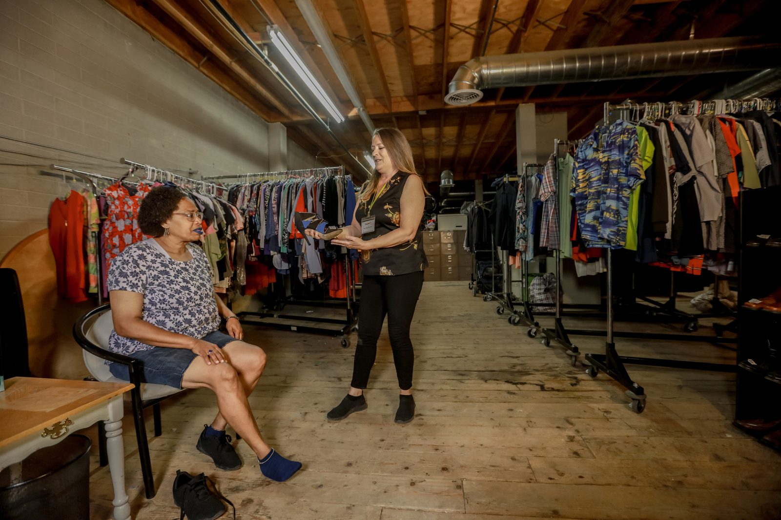Volunteer assists client in clothing donation room