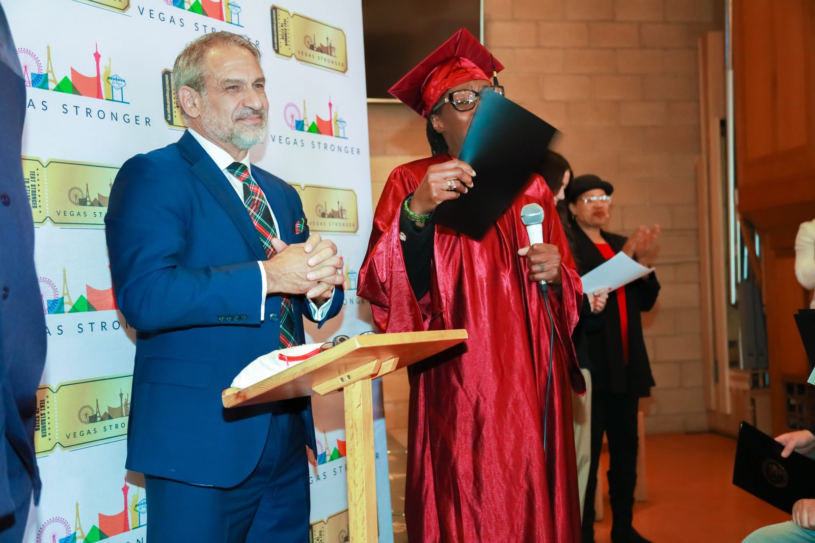Presenter listens to graduate speech at Vegas Stronger event