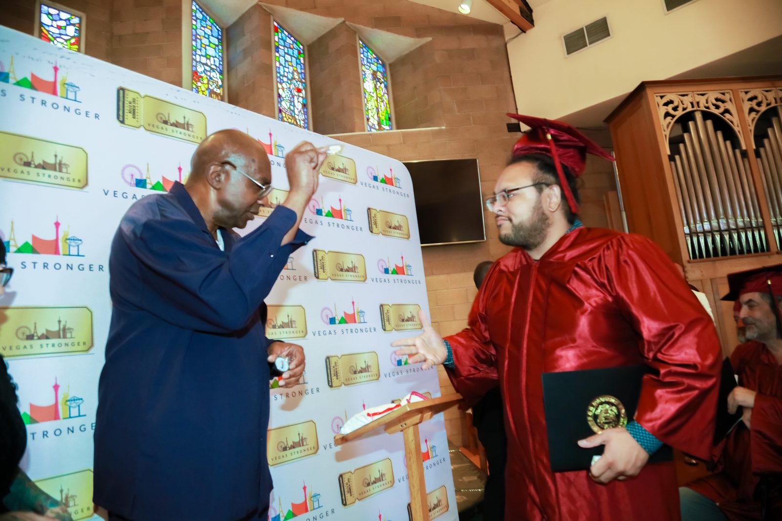 Staff member signs document beside recovery program graduate