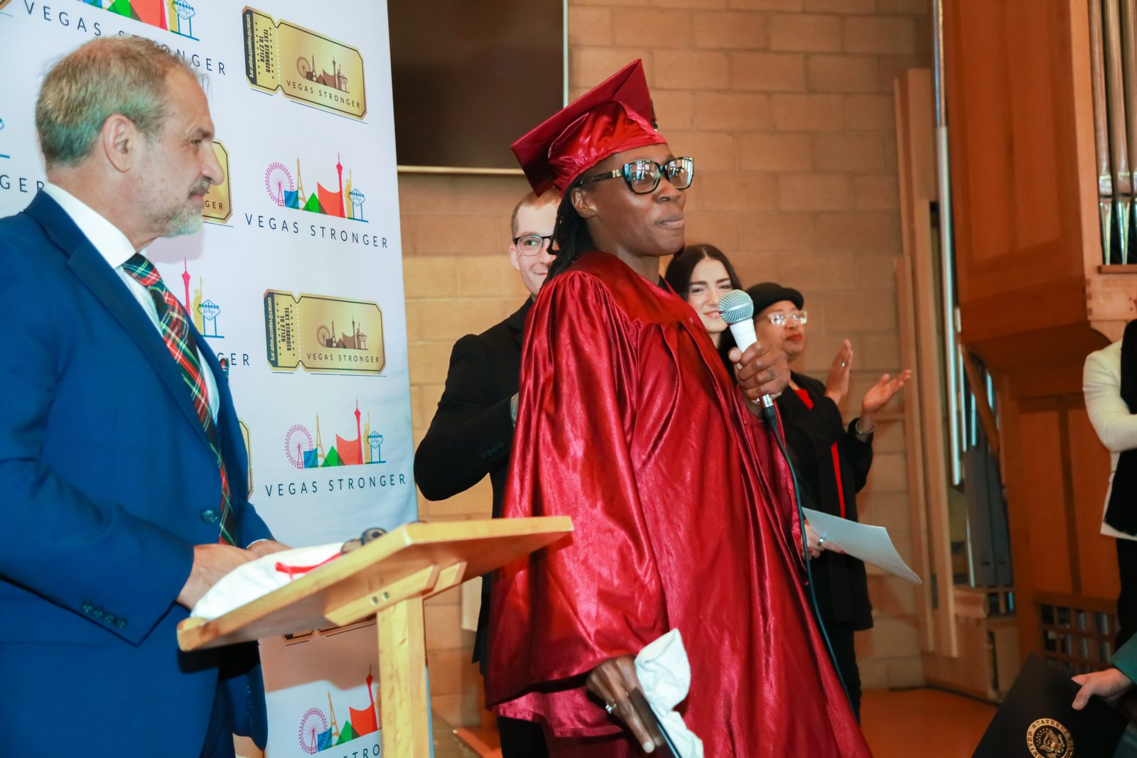 Graduate speaks near seated peers at Vegas Stronger event