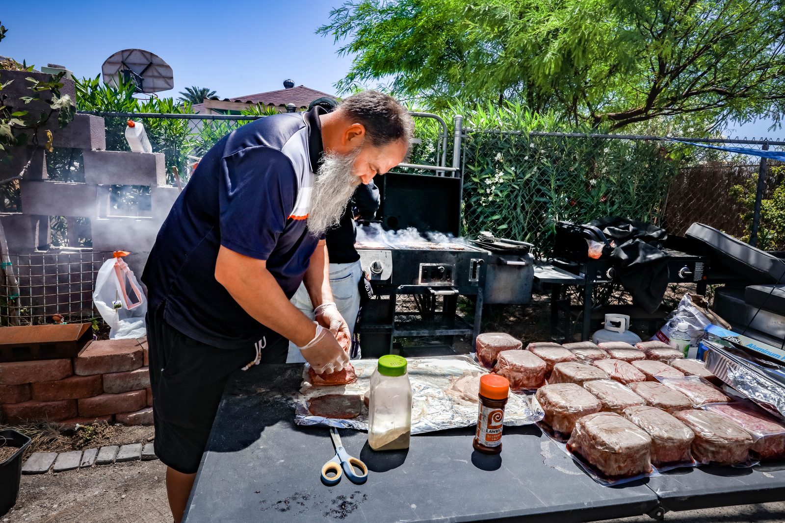 Man preparing burger patties for community cookout