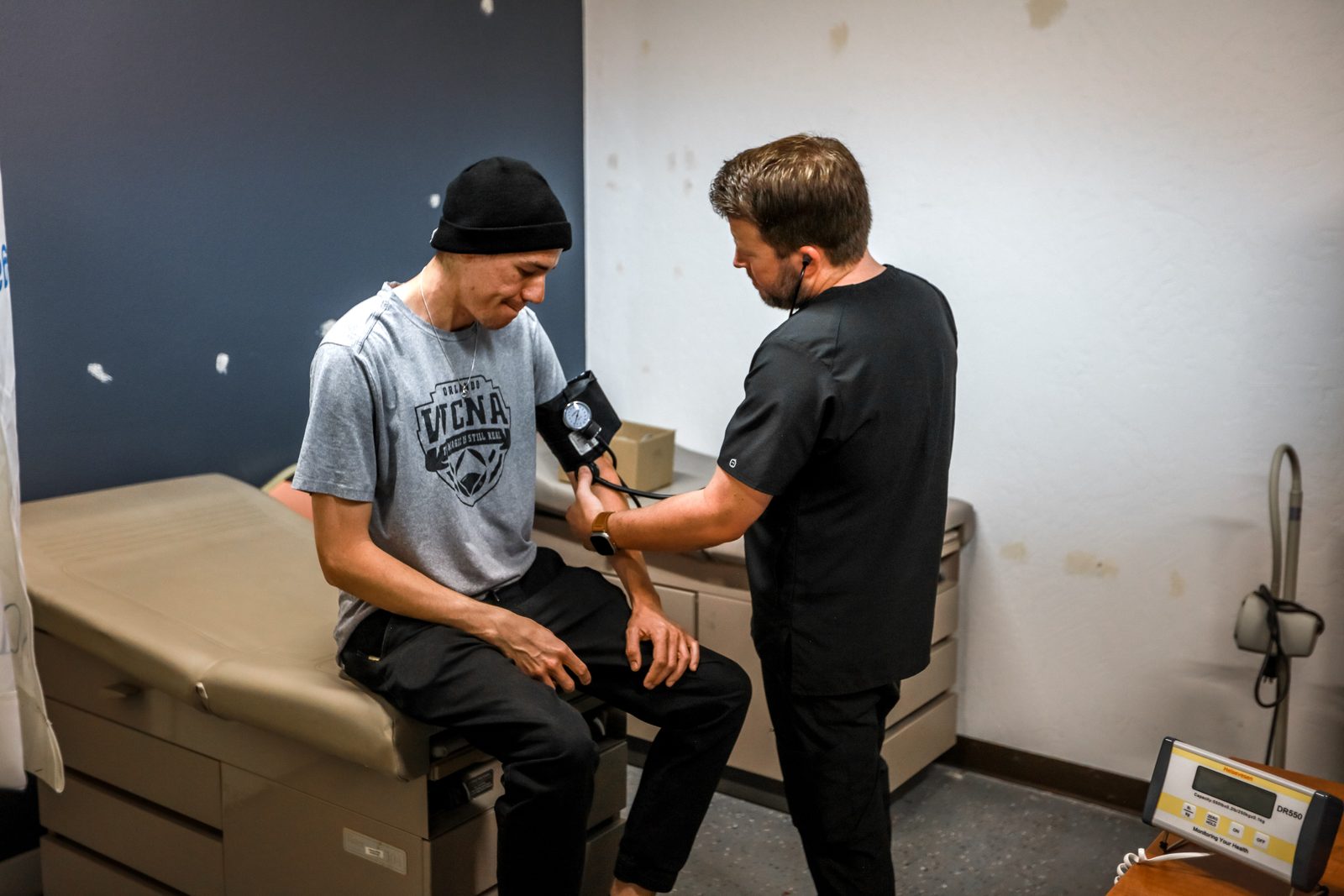 Medical staff taking blood pressure of client
