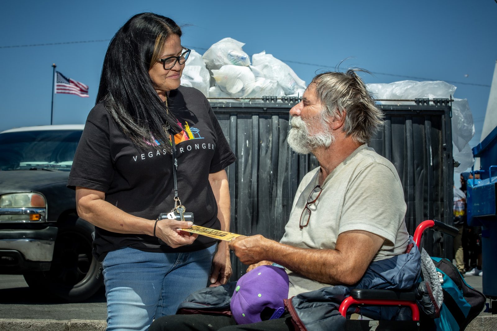 Staff member smiles helping homeless man with paperwork