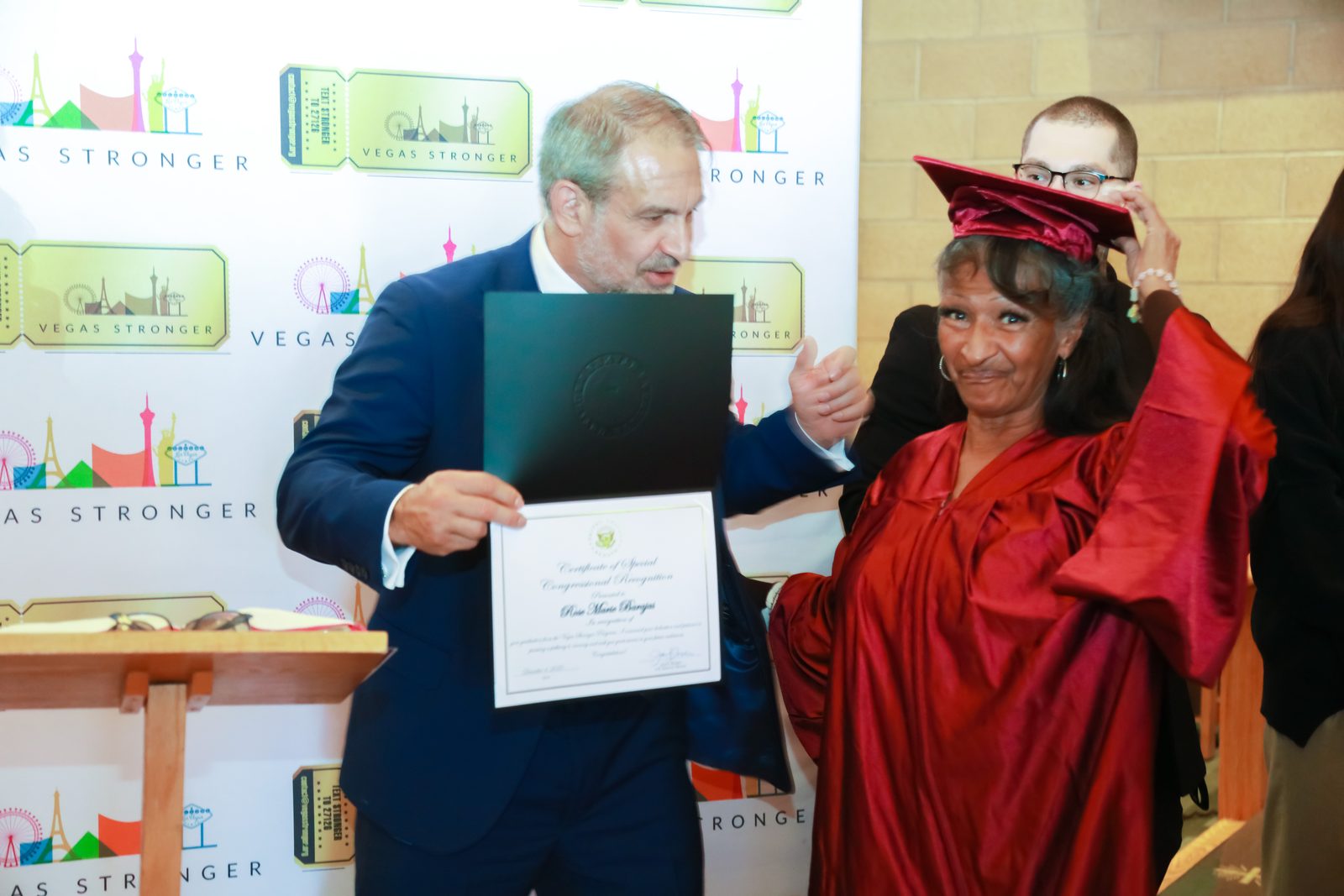 Recovery program graduate in red gown receives certificate