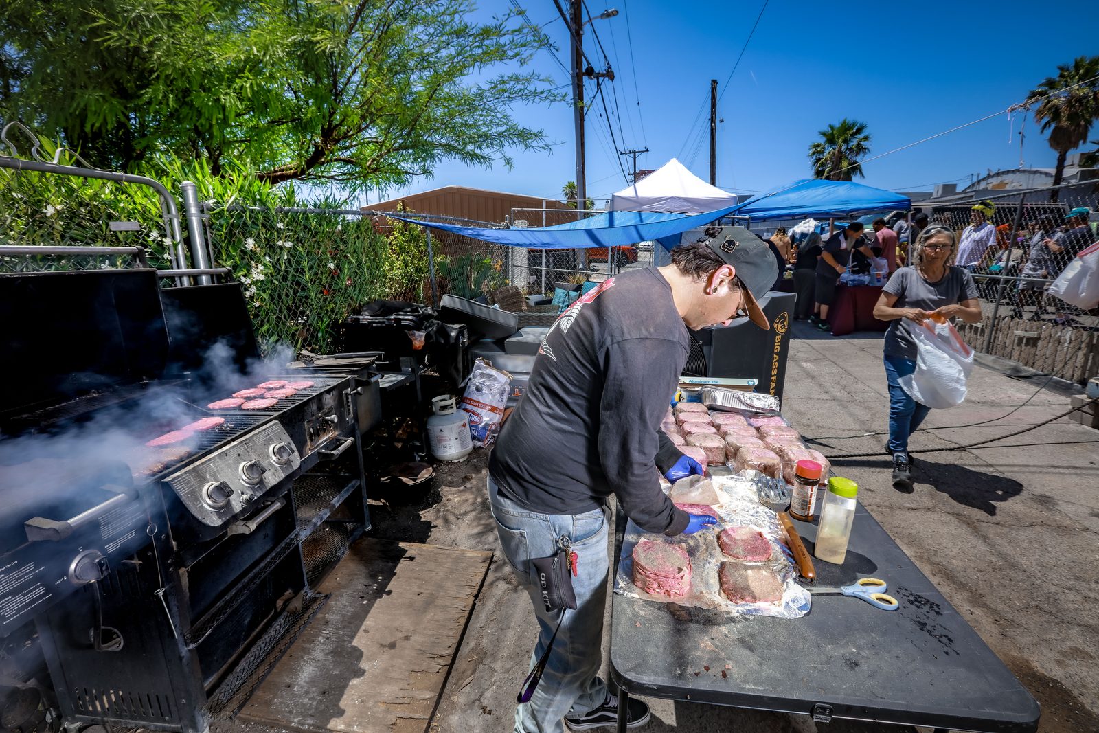 Man grilling burgers at community cookout event